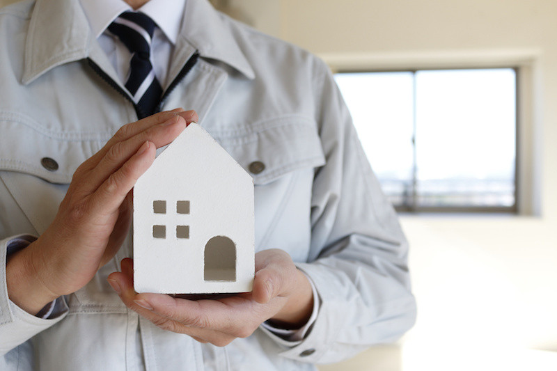 家の模型を持っている作業員